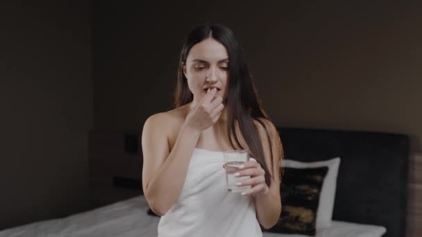 Woman Taking Pill Drinking Water Glass White Towel — Stok video