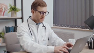 otolaryngologist search or read journal of human ear anatomy to diagnose about eardrum symptom by use laptop at office for healthcare concept