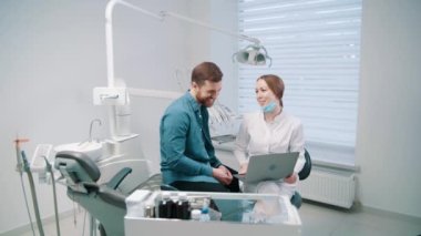 A female doctor discusses a dental restoration and rehabilitation plan with a patient. Dentistry