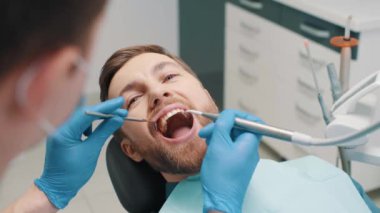 Treatment of teeth in a male patient, a dentist performs a hygienic cleaning of the teeth from caries. Dental clinic