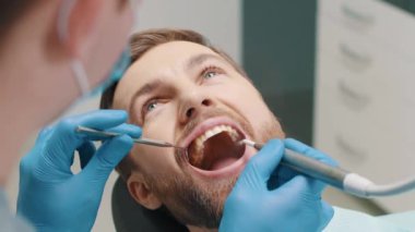 Treatment of teeth in a male patient, a dentist performs a hygienic cleaning of the teeth from caries. Dental clinic