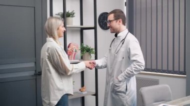 Tıpta, Güzel Sarışın Bir Kadın ile Doktor Konuşuyor. Modern Ofiste Sağlık Hizmetleri Profesyonel Danışmanlık