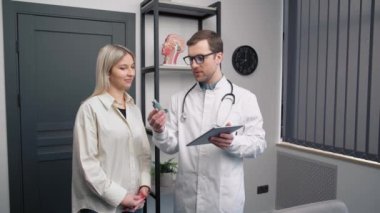 KBB doktorunun hastayla görüşmesi. Astım ilacı olan bir erkek doktor.
