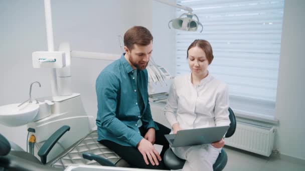 Female Doctor Discusses Dental Restoration Rehabilitation Plan Patient Laptop Dentistry — Stock Video