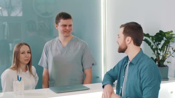 Pasien Muda Setelah Berhasil Perawatan Gigi Meja Resepsionis Tersenyum — Stok Video