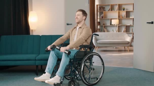 Mladý Atraktivní Usmívající Muž Invalidním Vozíku Zvedání Činky Slunném Pokoji — Stock video