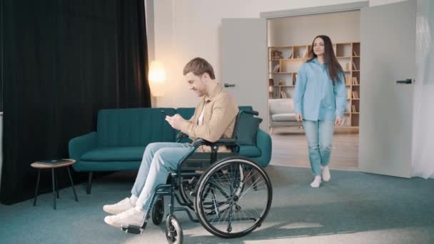 Biała Żona Wspierać Młodego Męża Siedzieć Wózku Inwalidzkim Domu Atrakcyjna — Wideo stockowe