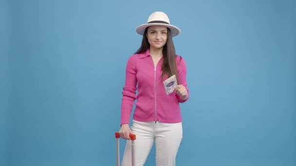 Счастливая Молодая Девушка Белой Шляпе Чемоданом Паспортом Голубом Фоне Студии — стоковое видео