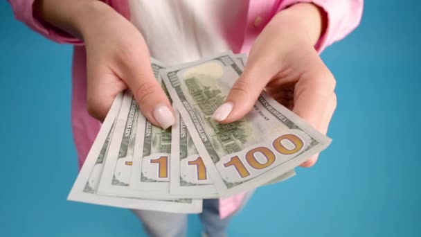 百ドルの米ドル紙幣の山を数える閉鎖的な女性の手 ビジネスマンは現金を数えている お金の交換 賄賂や汚職の概念 青の背景 — ストック動画