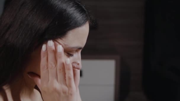 Расстроенная Молодая Женщина Сидящая Кровати Трется Висок Закрытыми Глазами Страдает — стоковое видео