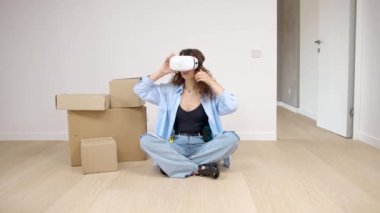 İç tasarım gözlüklü genç bir kadın oturma odasında oturuyor. Modern apartman tasarımı