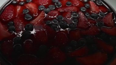 Siyah arka planda çilekli cheesecake karışımı. Yavaş çekim