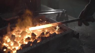 Demirci demir ocağında metalle çalışır. İnsan demiri hazırlar. Yavaş çekim