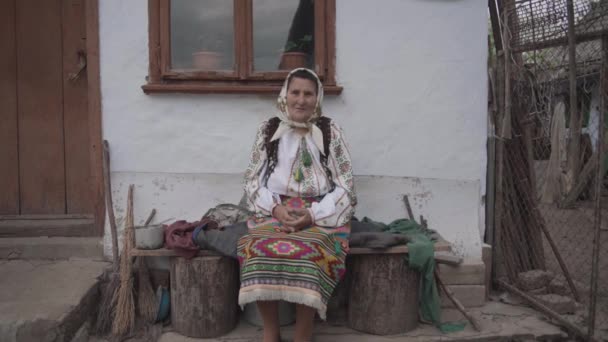 Old Woman Ukrainian Symbols Sits Old House — Stock Video