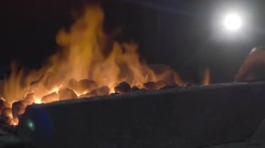 Demirci demir ocağında metalle çalışır. İnsan demiri hazırlar. Yavaş çekim