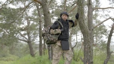 Boşaltılıyor. Sırt çantalı bir asker ağaçların yanında yürüyor. Mayınlar etkisiz hale getiriliyor