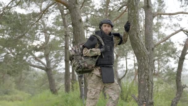 提着背包的士兵走在树边 使地雷中立 — 图库视频影像