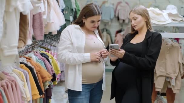 Dos Mujeres Embarazadas Felices Comprando Ropa Tienda Del Bebé Mire — Vídeo de stock