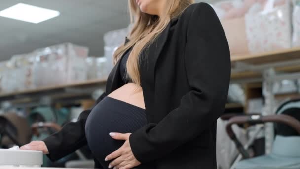怀孕妇女在超市里摸她的肚子 年轻的妈妈在购物 — 图库视频影像