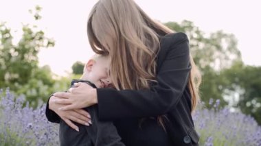 Mutlu bir aile. Park 'ta oğlu olan genç hamile bir anne. Aile birlikte zaman geçirir. Anne oğluna sarılıyor. Parkta aile gezisi.