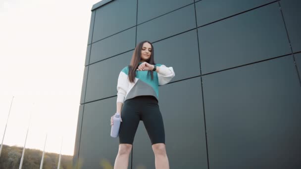 Jovem Sportswear Com Uma Garrafa Olhar Relógio Inteligente Enquanto Jogging — Vídeo de Stock