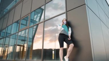 Spor molası sırasında spor şişesinden içen fitness kızı. Eğitimden dinlenirken su şişesinden içen aktif bir kadın. Yavaş çekim