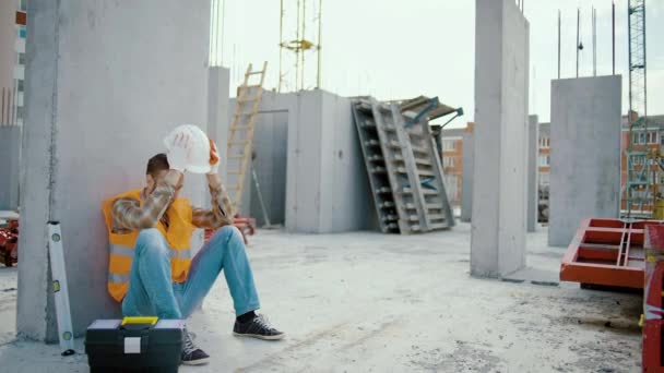 Joven Trabajador Hombre Cansado Sentado Quita Sombrero Blanco Lugar Trabajo — Vídeos de Stock