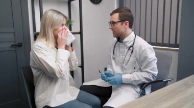 Modern hastanede otoskopla burun muayenesi yapan profesyonel bir erkek doktor. Burun tıkanıklığı, sinüzit, alerji konsepti.