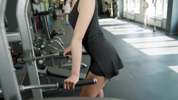 スポーツクラブのジムマシンでレッグエクササイズをしている若い女の子アスリート — ストック動画