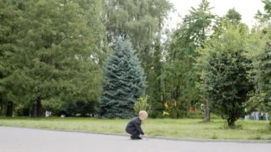 Parkta oyuncak arabayla oynayan mutlu çocuk. Gülen küçük çocuk dışarıda oynarken eğleniyor.