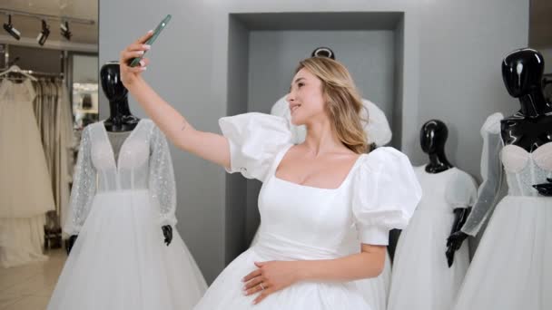 金发碧眼的新娘试穿婚纱时 用智能手机自拍的肖像 准备结婚概念 — 图库视频影像