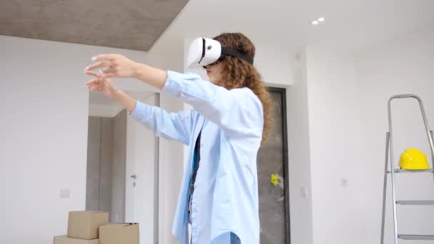 拡張現実技術を使用してVrヘッドセットを身に着けている若い現代の白人女性がアパートを再設計する — ストック動画