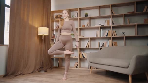 Chica Joven Está Haciendo Yoga Una Habitación Cerca Estantería — Vídeos de Stock