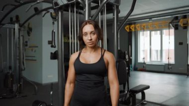 Spor giyinmiş, spor giyinmiş, fotoğraf makinesine sahip yorgun bir kadının portresi.