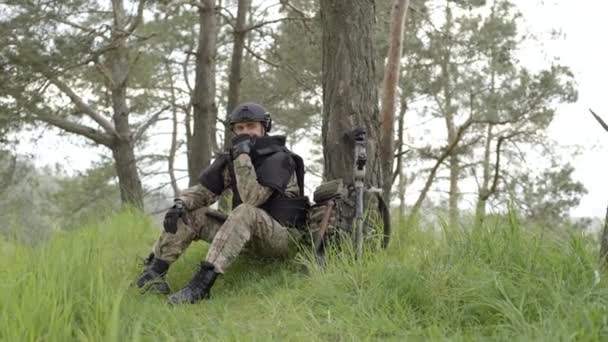俺の許可だ 地雷探知機とバックパックを持つ兵士は重い地雷除去後木によって疲れ座っ — ストック動画
