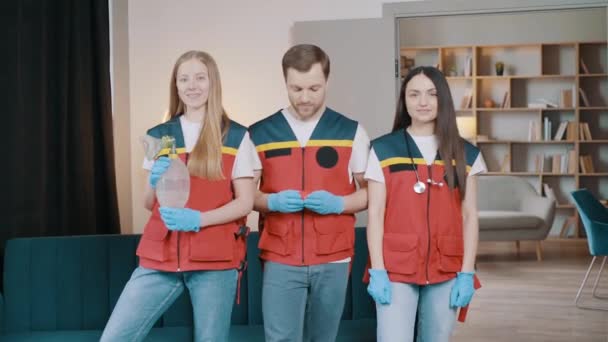 Profesjonalni Sanitariusze Patrzą Kamerę Mężczyzna Medyk Pokazuje Czerwone Serce — Wideo stockowe