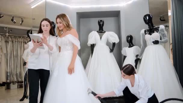 Właściciele Sklepów Sukni Ślubnej Tabletem Cyfrowym Pomaga Wybrać Suknię Ślubną — Wideo stockowe