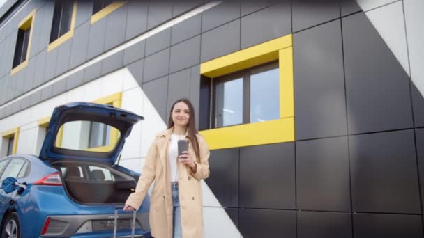 Kaukázusi Egy Csésze Kávéval Bőrönddel Aki Elektromos Autója Mellett Sétál — Stock videók