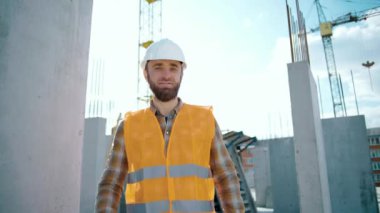 Kafkas kasklı beyaz teknisyen inşaat alanını gösteriyor. Tamam tabela fabrikası çalışması önerilir