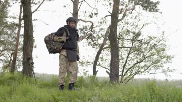 地雷除去 リュックを持った兵士が木の近くを歩く 鉱山を中和する — ストック動画