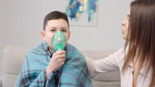 Madre Ayudando Hijo Enfermo Usar Nebulizador Mientras Abraza Sofá Casa — Vídeo de stock