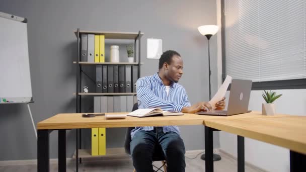 Młody Skupiony Afrykański Pracownik Dokumentami Otrzymujący List Czytający Dokumenty Prawne — Wideo stockowe