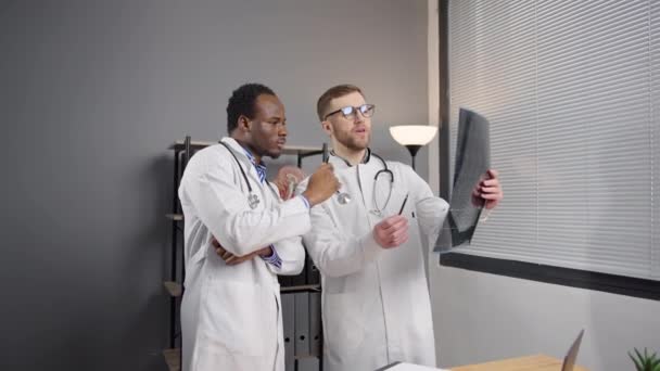 Два Человека Белых Халатах Анализируют Рентгеновское Изображение — стоковое видео