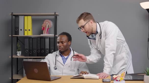 两名医生在诊所检查手提电脑屏风 — 图库视频影像
