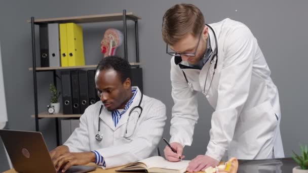 Αρσενικοί Γιατροί Εργάζονται Μαζί Φορητό Υπολογιστή Κλινική — Αρχείο Βίντεο