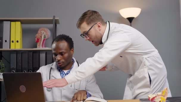 Two Doctors Lab Coats Examining Laptop Screen — Stock Video