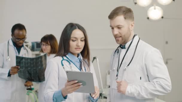 Група Лікарів Які Вивчають Медичні Зображення Планшеті — стокове відео