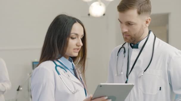 Kvinnliga Och Manliga Läkare Diskuterar Medicinsk Information Tablett Läkarmottagningen — Stockvideo
