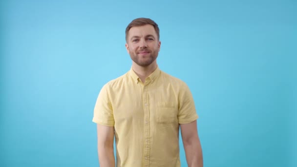 Άντρας Στέκεται Μπροστά Από Μπλε Φόντο Κίτρινες Τουλίπες Και Κοιτάζοντας — Αρχείο Βίντεο