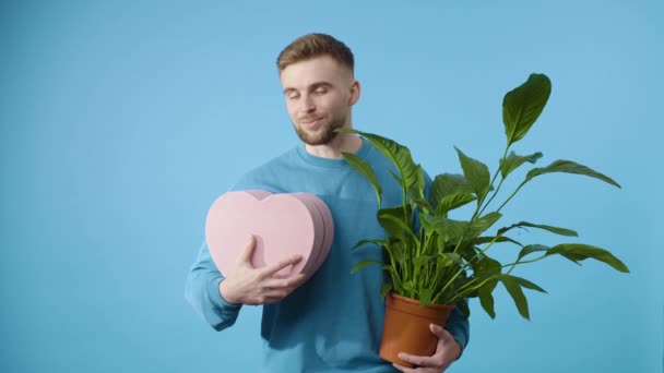 Homme Tenant Plante Pot Cadeau Forme Coeur Sur Fond Bleu — Video